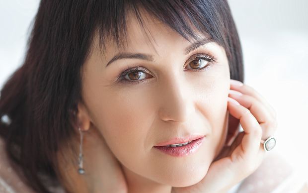 Mature woman smiling warmly for an online dating conversation