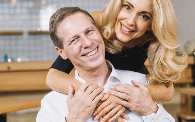 Mature couple smiling and hugging indoors
