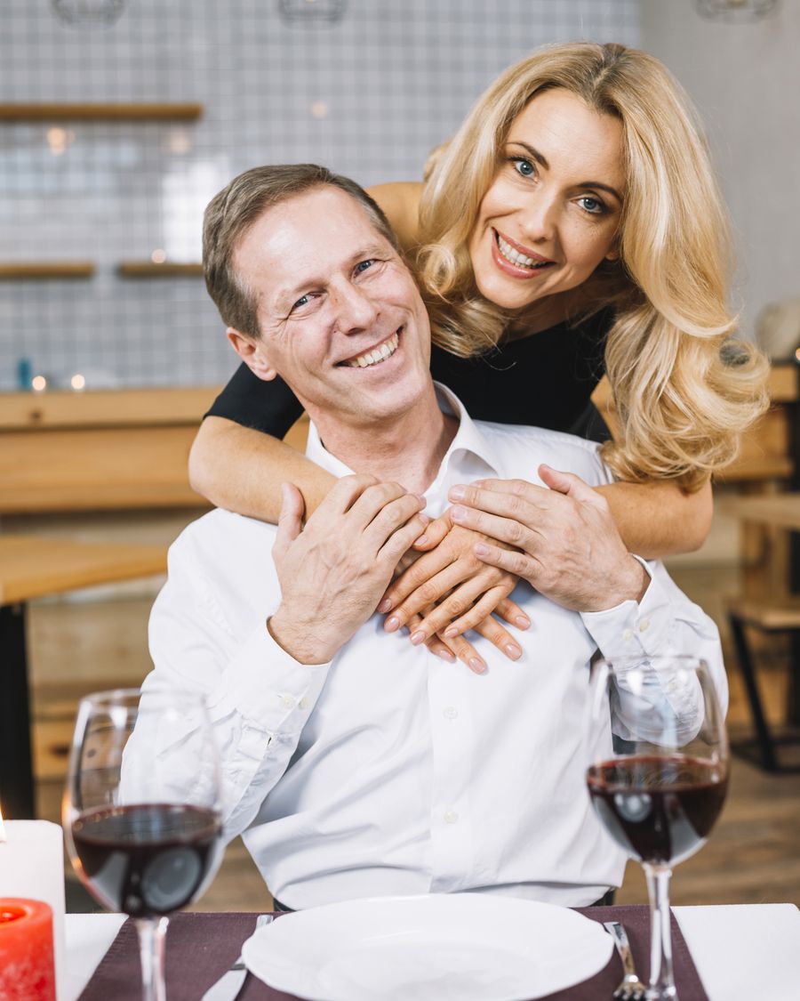 Mature couple smiling and hugging indoors